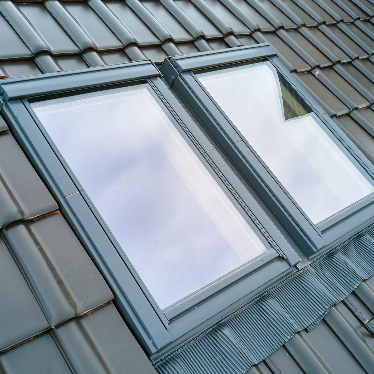 Zwei fertig eingebaute und abgedichtete Dachfenster mit Eindeckrahmen in einer Tondachziegel-Fläche