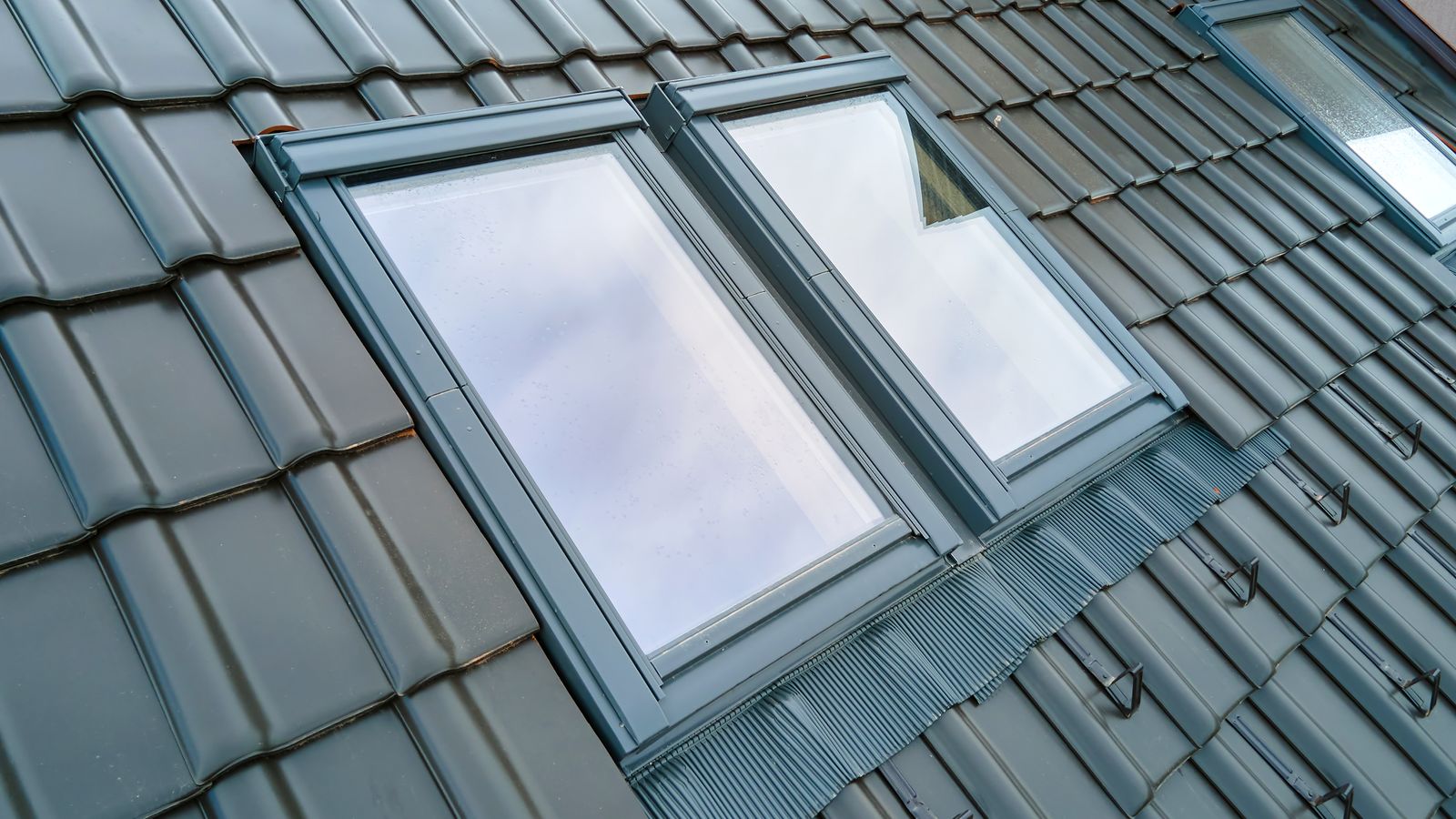 Zwei fertig eingebaute und abgedichtete Dachfenster mit Eindeckrahmen in einer Tondachziegel-Fläche
