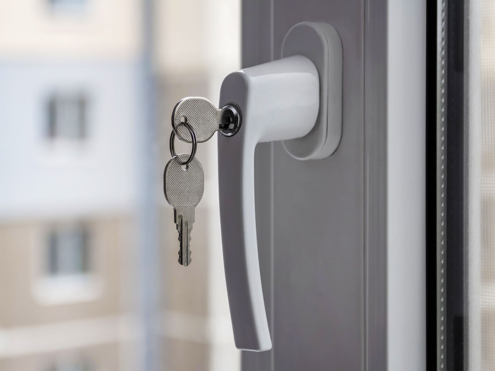 Abschließbarer Fenstergriff mit Schloss und gestecktem Schlüssel als Einbruchschutz für Fenster